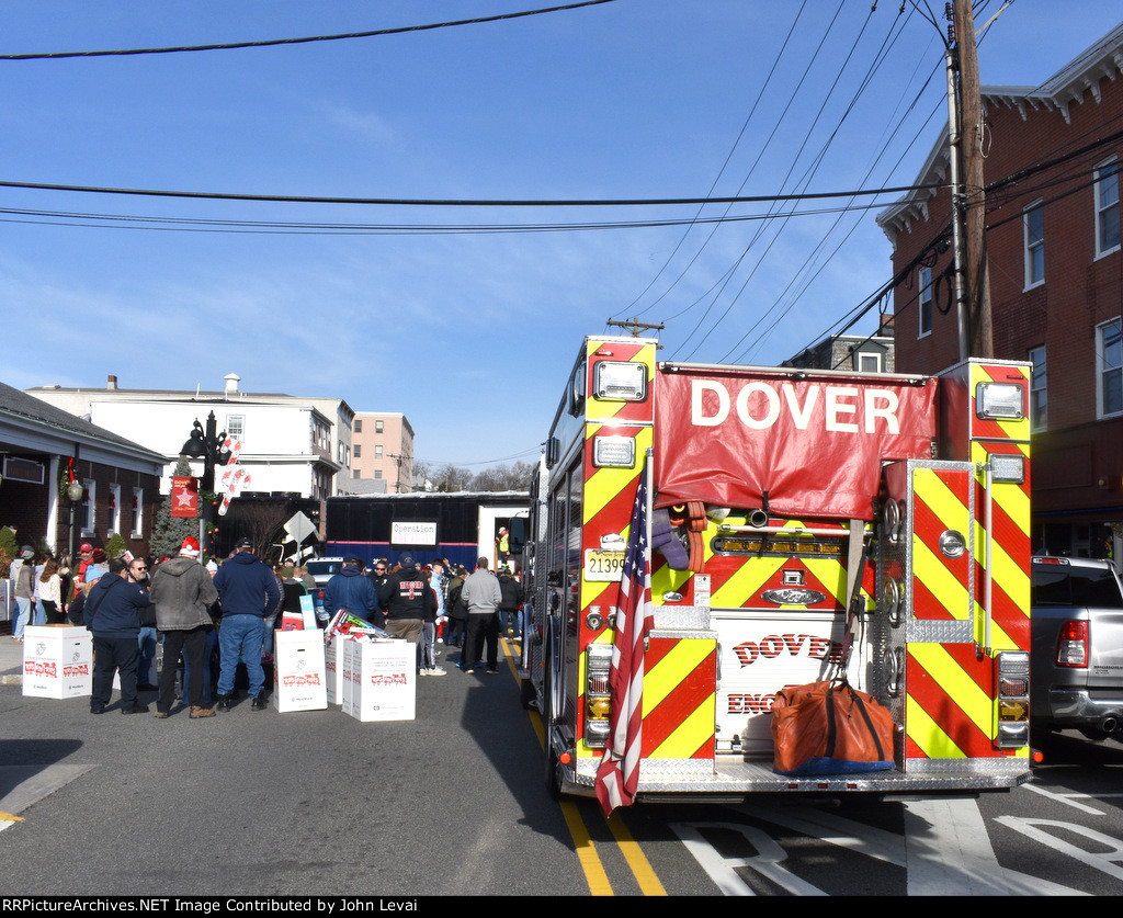 A Dover, NJ fire engine is part of the Toys for Tots festivities in Downtown Dover as the train sits in the background 